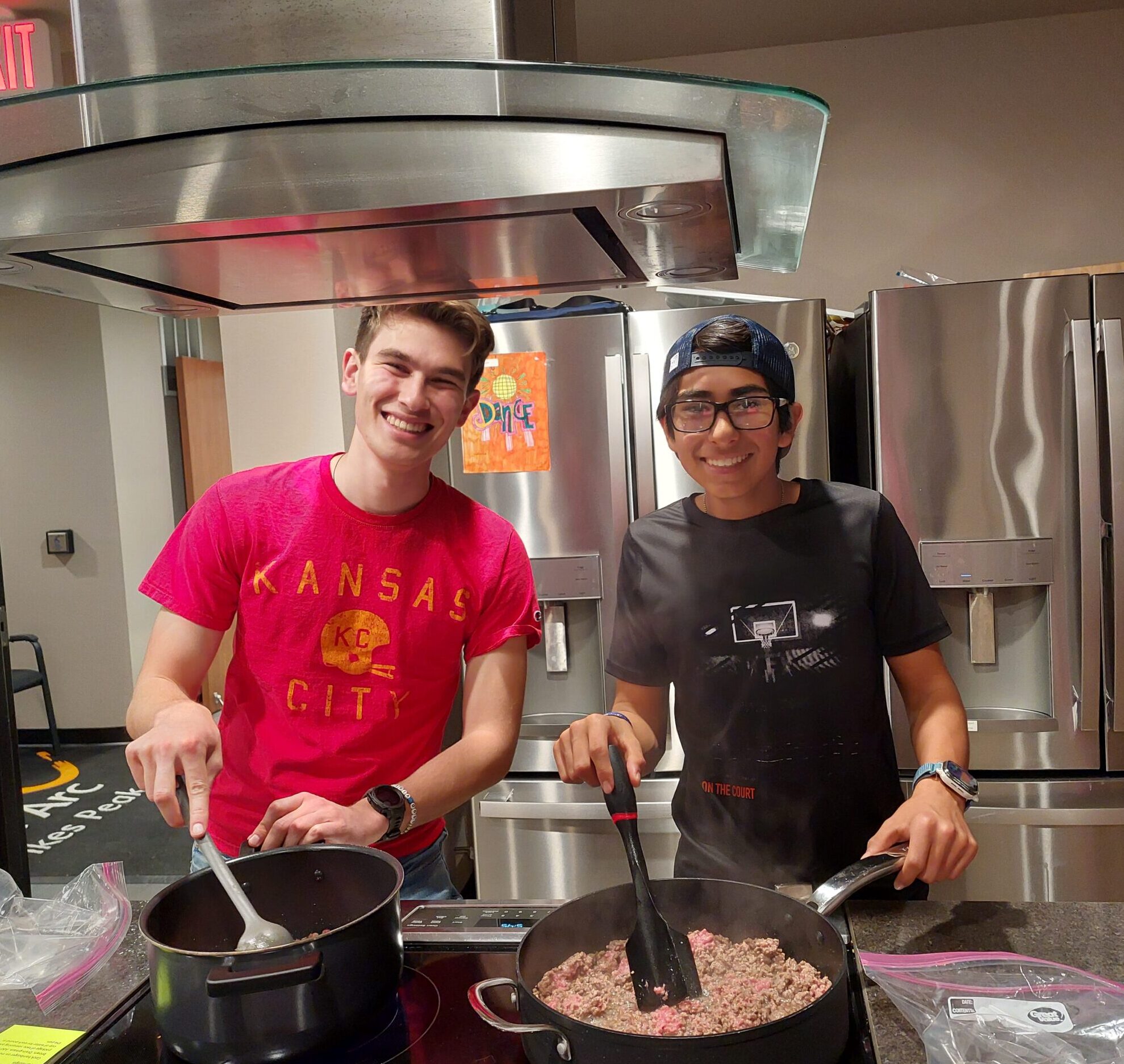 two young adults prepare food in a kitchen setting