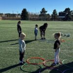 Young children on soccer field with hoops